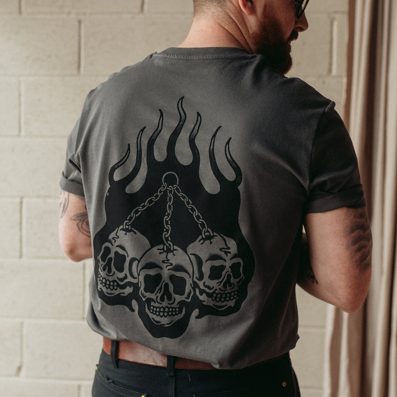 Traditional tattoo chained skull in flames on a unisex grey t-shirt
