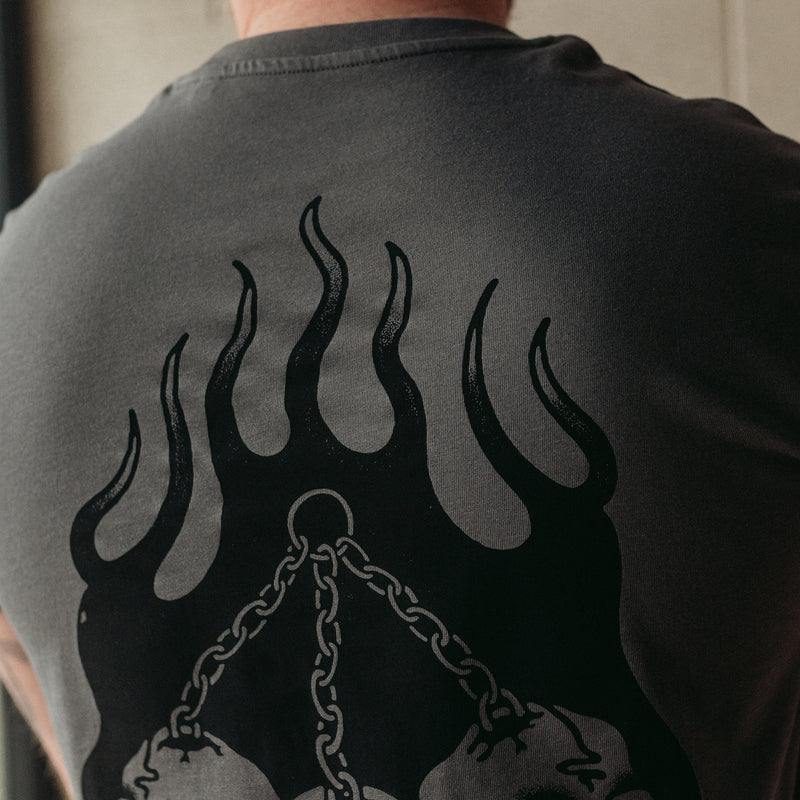 Traditional tattoo chained skull in flames on a unisex grey t-shirt
